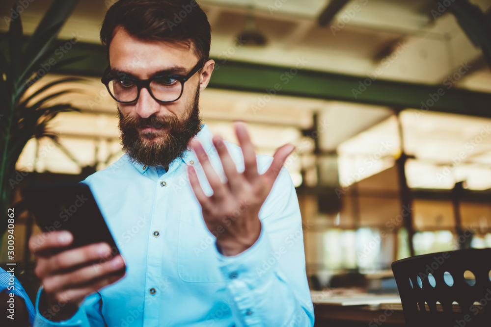 Poster shocked bearded hipster guy amazed from received email via application on smartphone device connecte