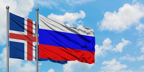 Iceland and Russia flag waving in the wind against white cloudy blue sky together. Diplomacy concept, international relations.