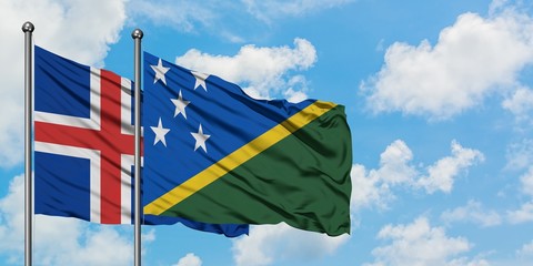 Iceland and Solomon Islands flag waving in the wind against white cloudy blue sky together. Diplomacy concept, international relations.