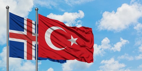 Iceland and Turkey flag waving in the wind against white cloudy blue sky together. Diplomacy...