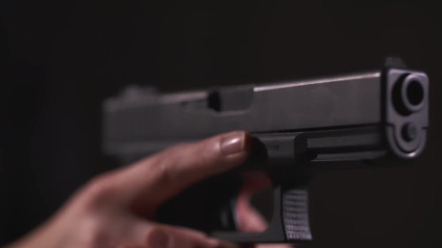 Close-Up Slow Motion Shot of Hand Holding a Pistol With Propper Trigger Discipline