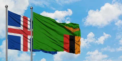 Iceland and Zambia flag waving in the wind against white cloudy blue sky together. Diplomacy...