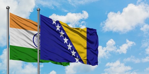 India and Bosnia Herzegovina flag waving in the wind against white cloudy blue sky together. Diplomacy concept, international relations.