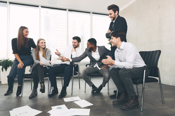 Teamwork and brainstorming. Colleagues discussing blueprints in office