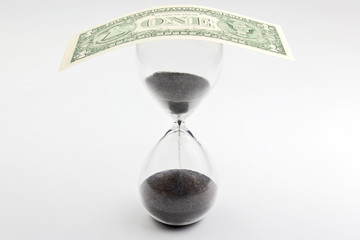 Dollar bill lies on the hourglass. Time is money. Salary. Business solutions in time.