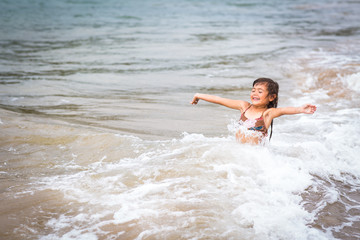 Fototapeta premium young girl full of joy arms out in the ocean