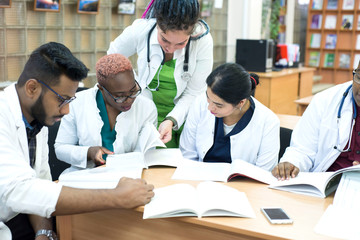 a group of young doctors, mixed race. Sitting at the table, colleagues discuss medical topics