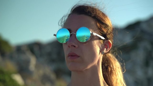 Reflection of island peninsula off woman's polarized sunglasses