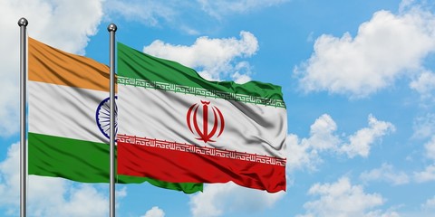 India and Iran flag waving in the wind against white cloudy blue sky together. Diplomacy concept,...