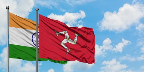 India and Isle Of Man flag waving in the wind against white cloudy blue sky together. Diplomacy concept, international relations.