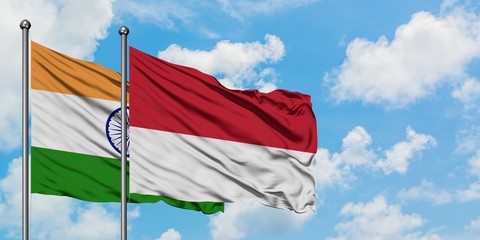 India and Monaco flag waving in the wind against white cloudy blue sky together. Diplomacy concept, international relations.