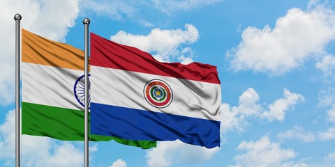 India and Paraguay flag waving in the wind against white cloudy blue sky together. Diplomacy concept, international relations.