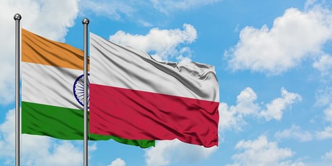 India and Poland flag waving in the wind against white cloudy blue sky together. Diplomacy concept, international relations.