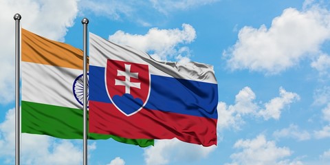 India and Slovakia flag waving in the wind against white cloudy blue sky together. Diplomacy concept, international relations.