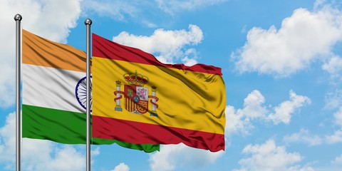India and Spain flag waving in the wind against white cloudy blue sky together. Diplomacy concept, international relations.