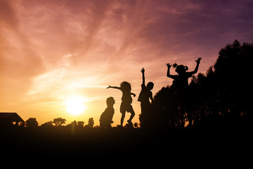 Fototapeta na wymiar silhouette of lifestyle children active playing up hands and jumping joy on summer