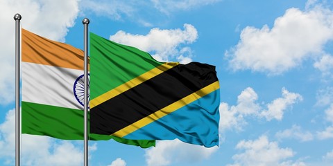 India and Tanzania flag waving in the wind against white cloudy blue sky together. Diplomacy concept, international relations.