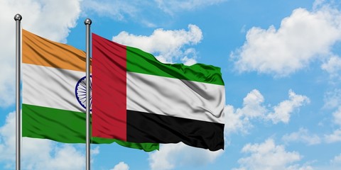 India and United Arab Emirates flag waving in the wind against white cloudy blue sky together. Diplomacy concept, international relations.