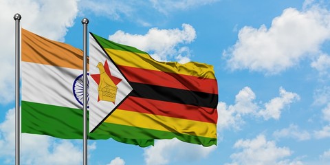 India and Zimbabwe flag waving in the wind against white cloudy blue sky together. Diplomacy concept, international relations.