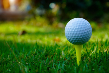 Golf ball on tee in beautiful golf course.