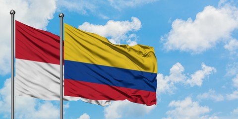 Iraq and Colombia flag waving in the wind against white cloudy blue sky together. Diplomacy concept, international relations.