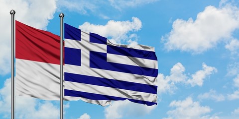 Iraq and Greece flag waving in the wind against white cloudy blue sky together. Diplomacy concept, international relations.