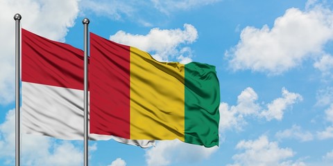 Iraq and Guinea flag waving in the wind against white cloudy blue sky together. Diplomacy concept, international relations.