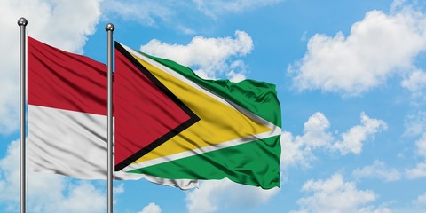 Iraq and Guyana flag waving in the wind against white cloudy blue sky together. Diplomacy concept, international relations.