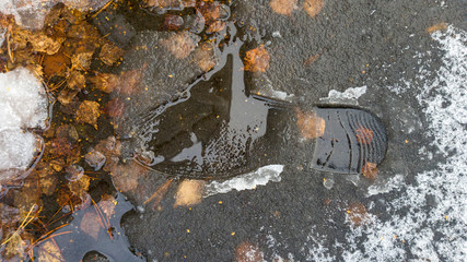A shoe and boot print on the melted snow, winter. Classic shoe print shape. On the background of...