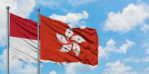 Iraq and Hong Kong flag waving in the wind against white cloudy blue sky together. Diplomacy concept, international relations.