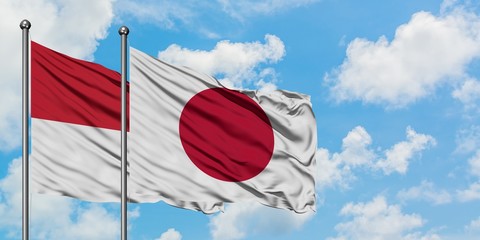 Iraq and Japan flag waving in the wind against white cloudy blue sky together. Diplomacy concept, international relations.