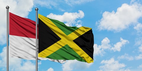 Iraq and Jamaica flag waving in the wind against white cloudy blue sky together. Diplomacy concept, international relations.