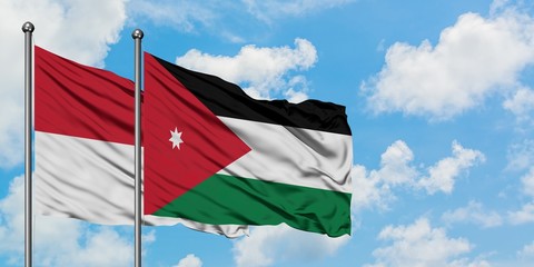 Iraq and Jordan flag waving in the wind against white cloudy blue sky together. Diplomacy concept, international relations.