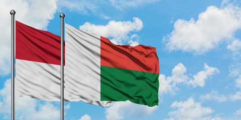 Iraq and Madagascar flag waving in the wind against white cloudy blue sky together. Diplomacy concept, international relations.