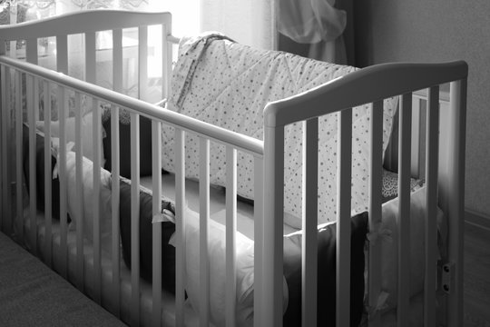 Baby bed crib with white and Burgundy color pillows with laces