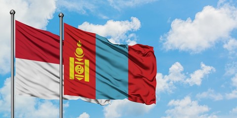 Iraq and Mongolia flag waving in the wind against white cloudy blue sky together. Diplomacy concept, international relations.