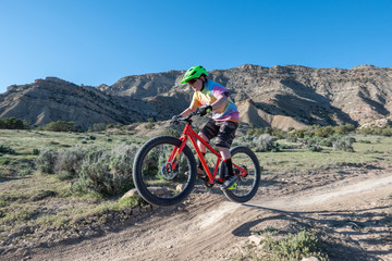 A young boy riding his mountain bike on the trails in Fruita, Colorado