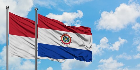 Iraq and Paraguay flag waving in the wind against white cloudy blue sky together. Diplomacy concept, international relations.