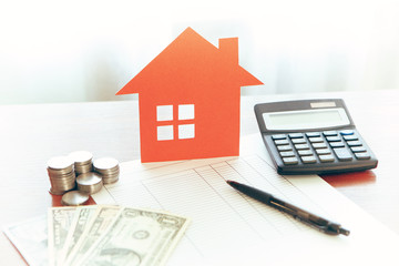 Buying and selling houses and real estate prices. Concept. Man using calculator to count rent money.