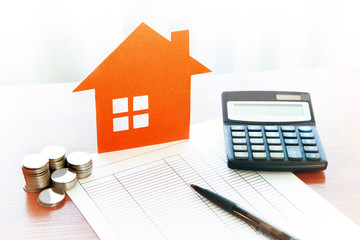 Buying and selling houses and real estate prices. Concept. Man using calculator to count rent money.