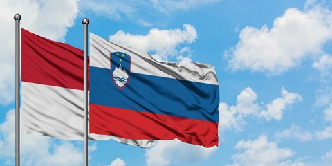 Iraq and Slovenia flag waving in the wind against white cloudy blue sky together. Diplomacy concept, international relations.