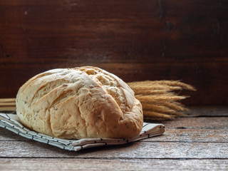 One of big french bun on wood table with dark nature light for bakery or food issue.