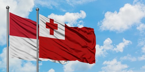 Iraq and Tonga flag waving in the wind against white cloudy blue sky together. Diplomacy concept, international relations.