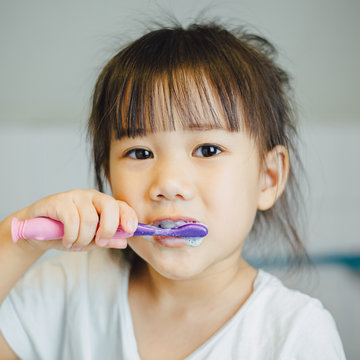Little kids brushing teeth by herself as activity daily living in the morning. Dental care grooming hygien for tooth & gums health.