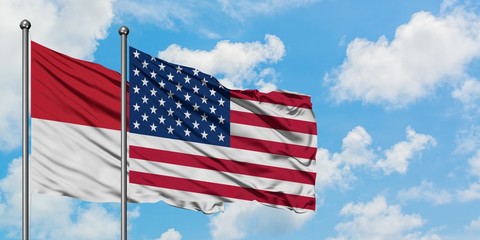 Iraq and United States flag waving in the wind against white cloudy blue sky together. Diplomacy concept, international relations.