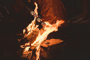 Marshmallow cook food on the Rock cave fire with sparks flying around. hiking,climbing ,camping concept.