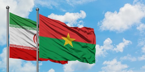 Iran and Burkina Faso flag waving in the wind against white cloudy blue sky together. Diplomacy concept, international relations.