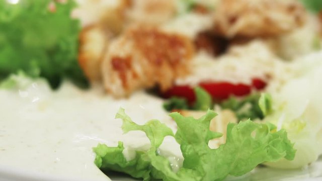 Fresh Caesar salad with chicken, vegetables, eggs and chopped lettuce covered with delicious sauce and parmesan cheese. Shot in 4k UHD