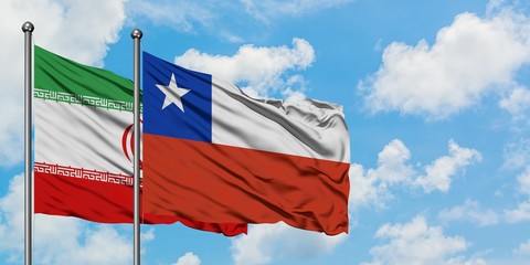 Iran and Chile flag waving in the wind against white cloudy blue sky together. Diplomacy concept, international relations.