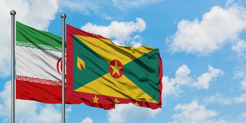 Iran and Grenada flag waving in the wind against white cloudy blue sky together. Diplomacy concept, international relations.